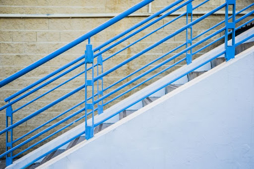 modré kovové zábradlie na schodisku